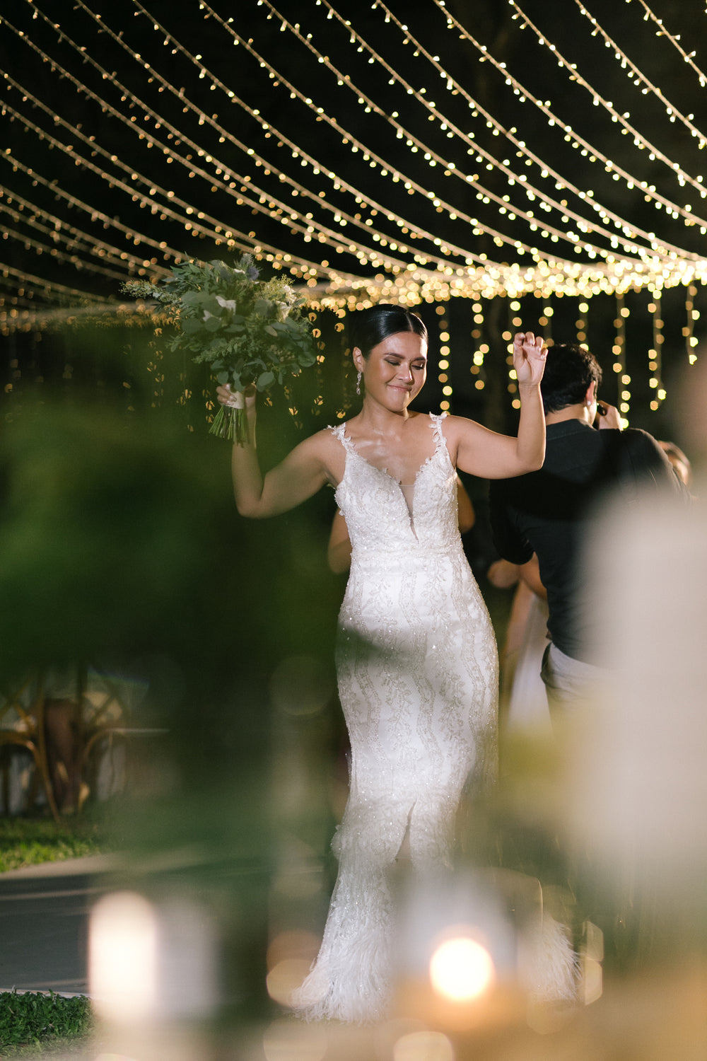A bride celebrating beneath warm garden lights
